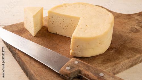 Semi-cured cheese, a table with semi-cured cheese and accessories in the interior of Brazil, selective focus.
