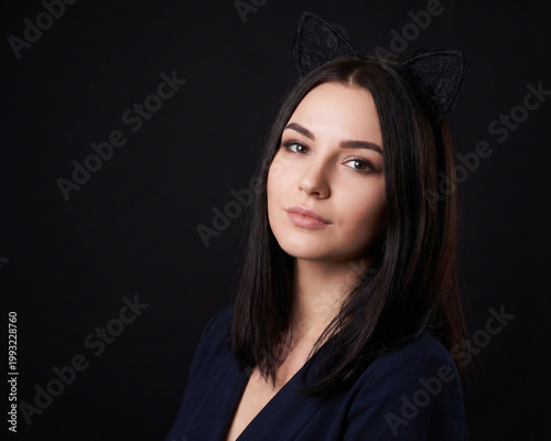 Attractive woman wearing cat ears on black background
