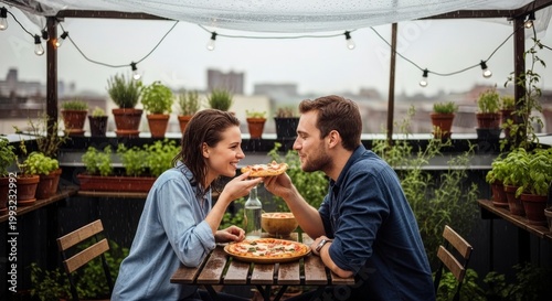 Couple eating pizza on a rainy rooftop