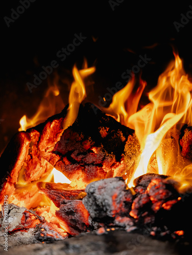 Fotografie A close-up of powerful flames engulfing firewood