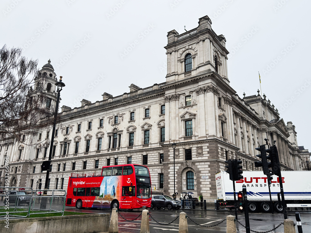 Fototapeta premium Red double decker bus passing a historic government building in Whitehall, London, UK