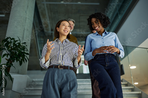 Happy diverse businesswomen having conversation in modern office
