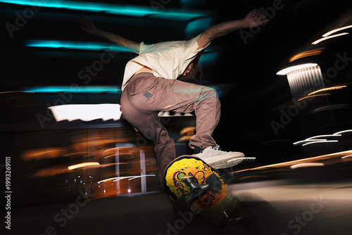 Obraz na plátně Skateboarder performing trick at night with motion blur