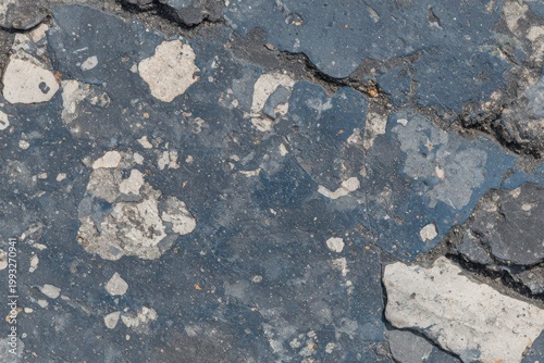 Close Up View of Weathered Asphalt Texture with Cracks and Abstract Patterns in Urban Environment
