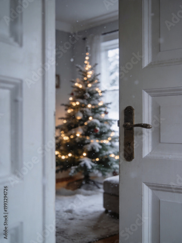 snow covered christmas tree with warm glowing lights viewed through open white doorway in cozy home interior winter holiday atmosphere