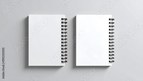 Two blank spiral notebooks on gray background.