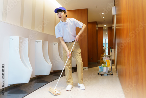 Foto オフィスビルのトイレの床を拭く若い日本人男性清掃員　撮影協力：学校法人電波学園 東京電子専門学校
