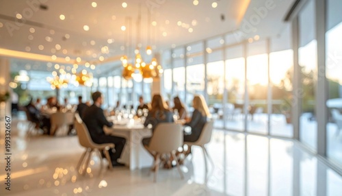 Professional group of colleagues having dinner at round table in modern brightly lit restaurant with warm glowing lights