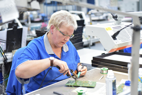 friendly woman working in a microelectronics manufacturing factory - component assembly and soldering