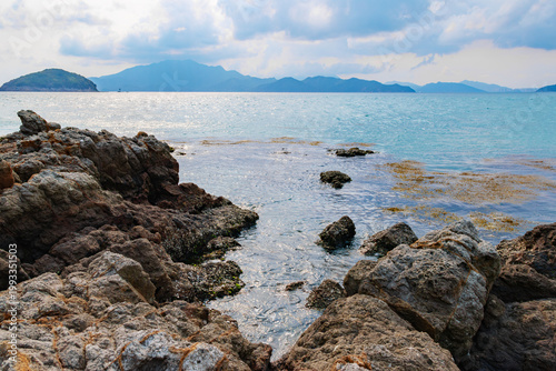 Cuadro en lienzo Island coastal reefs, shallow waters, seaweed, and distant mountain scenery in D