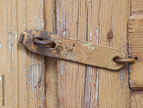 Foto Close-up of an aged wooden surface with distressed, peeling light brown paint and visible natural wood grain
