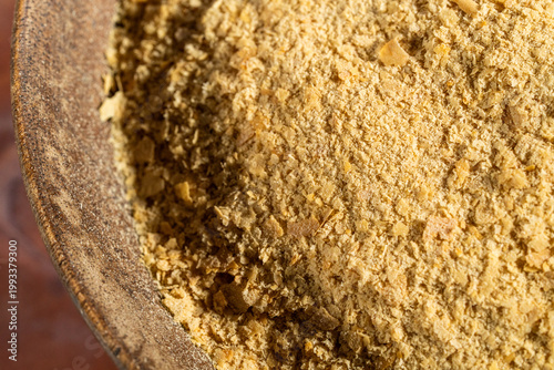 Nutritional Yeast in a wood bowl on a tile surface 