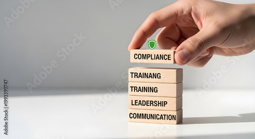 A hand placing a block with the word compliance on top of a stack of blocks with leadership and communication written on them.