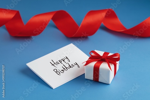 Gift and Card for Birthday Celebration on Blue Background With Red Ribbon