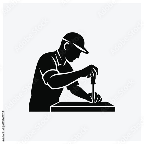 Silhouette of a craftsman working on a wooden surface with tools.