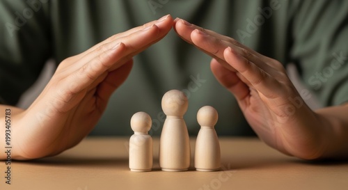 Family life insurance concept with protective hands over wooden figures, health and financial security symbol, home and property protection