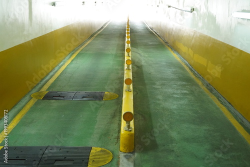 Symmetrical underground parking garage ramp with bright light exit