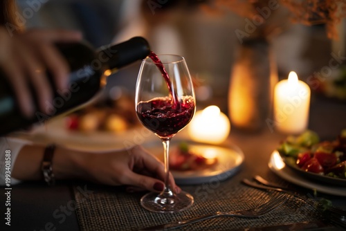 Wine is Poured Into a Glass During a Dinner Gathering With Friends at Home