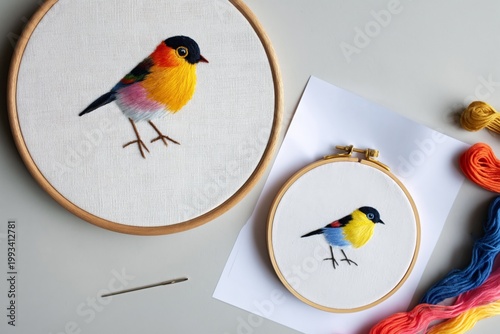 Colorful Bird Embroidery Works Displayed on a Table With Threads and a Needle