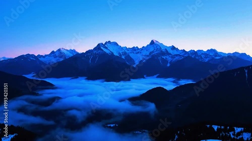 a mountain landscape at blue hour with slow drifting fog, static shot 