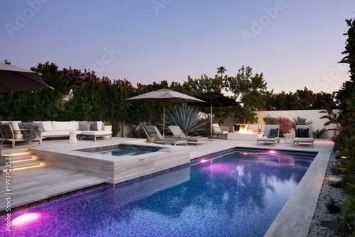Private Backyard With Pool and Lounge Area in Evening Light Near Tall Trees a...