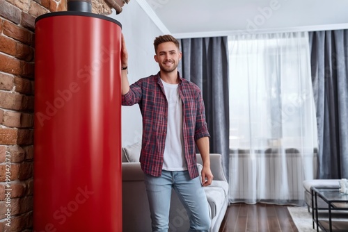 Man Stands Next to Red Cylinder in Modern Living Room During Daylight
