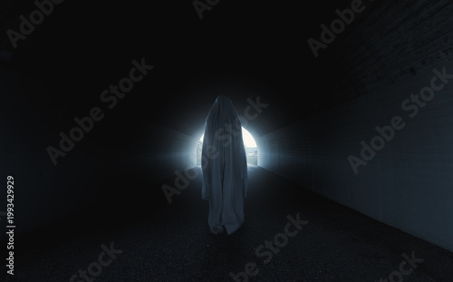 Digital composition of a scary white ghost standing in a dark concrete tunnel