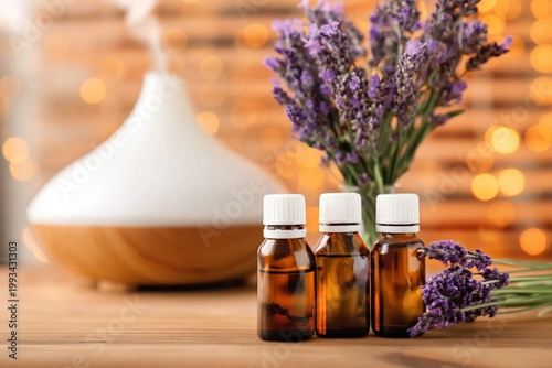 Lavender Oils and Diffuser Placed on Wooden Table With Lights in the Background