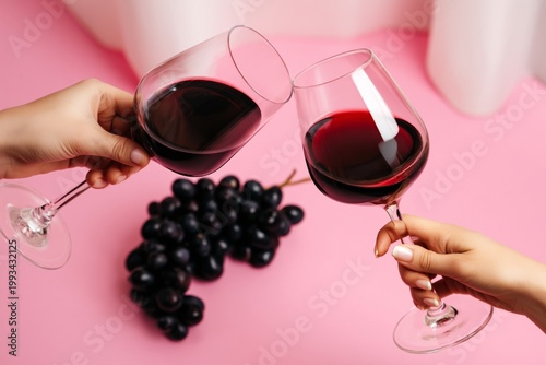 Cheers With Red Wine and Grapes on a Pink Background During a Gathering With ...