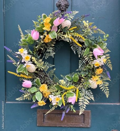 A decorative seasonal wreath on a traditional wood panelled door.