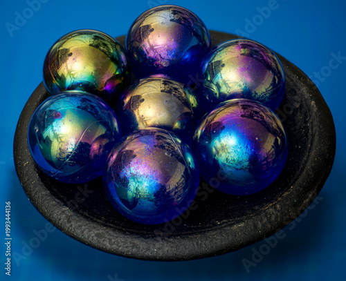 Antique glass balls (one-inch diameter) in old metal bowl.