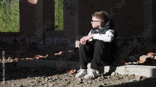 A teenage boy sits alone in an abandoned brick building after school, reflecting feelings of depression and bullying. 