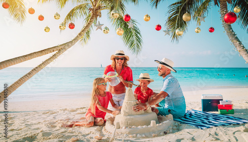 Family Building Sandcastle on Beach During Christmas Vacation