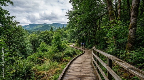 Wooden Boardwalk Trail Through Lush Green Forest with Hikers and Mountains