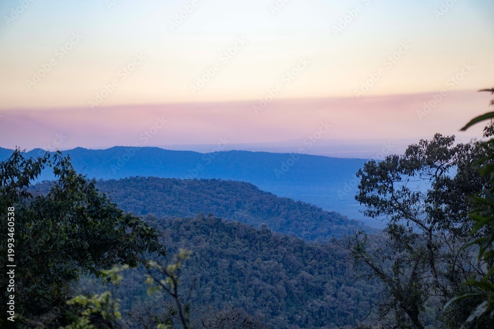 Obraz premium Beautiful sunset over the layered silhouettes of the Andes mountains in Argentina, featuring a purple and orange sky over a wild highland landscape
