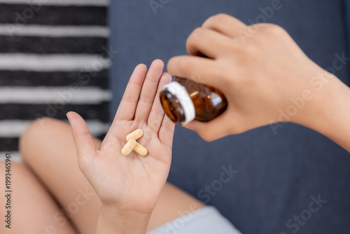 Fotografía Close up of hand holding pills from bottle, taking medication or vitamins, healt