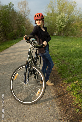 Wallpaper Mural Young woman cyclist with bicycle on an asphalt road in the countryside Torontodigital.ca
