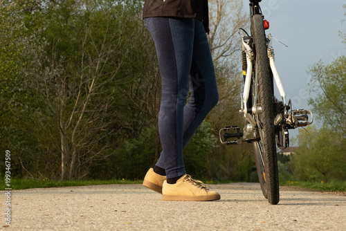 Wallpaper Mural Low angle shot of cyclists legs standing next to a bicycle Torontodigital.ca
