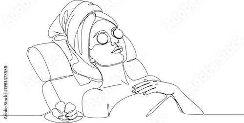Woman with towel and eye patches relaxing in spa treatment.