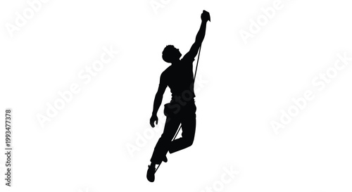 A rock climber reaching upwards with a rope captured in dark silhouette