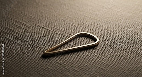 A small metal paperclip on a textured surface