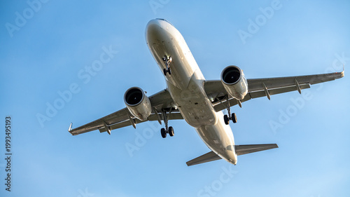Passenger airplane approaching for landing against clear sky, front view