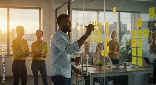 Strategic Session: A dynamic team engages in a brainstorming session, with a focused leader sharing innovative ideas through the use of sticky notes and transparent glass walls.