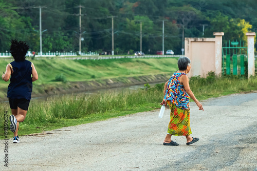 Healthy senior, pensioner, freedom female enjoy experiencing nature walking against breathing fresh air happy after retirement lifestyle. Senior woman taking deep breath while walk alone at lakeside.