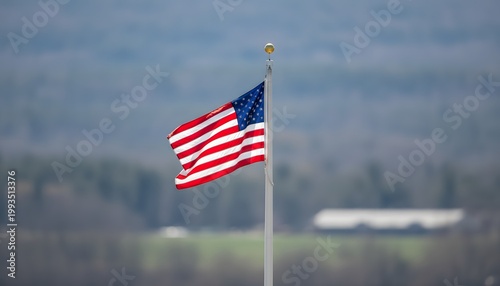 Windy American Flag on Flagpole in Open Landscape