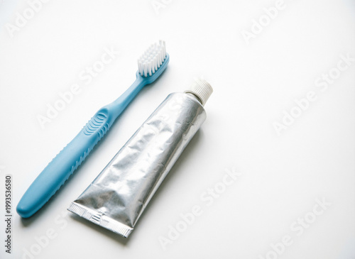toothbrush and toothpaste in a tube on white