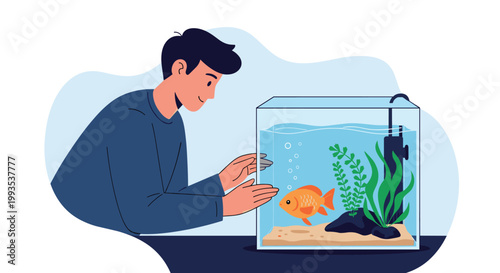 Curious young man leaning on a table to closely observe a bright orange goldfish swimming in a glass aquarium.