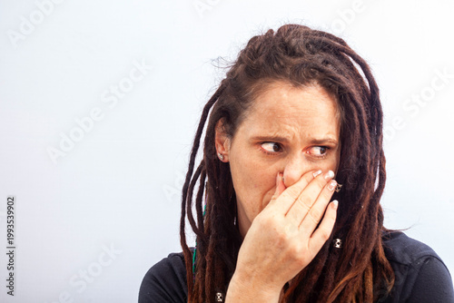 Woman reacting with disgust covering nose from bad smell