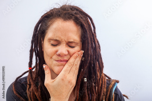 Woman suffering from toothache touching cheek in pain