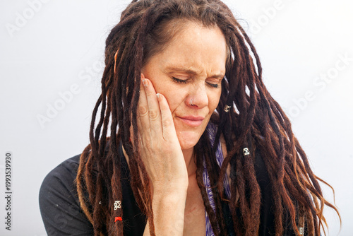 Woman suffering from toothache touching cheek in pain